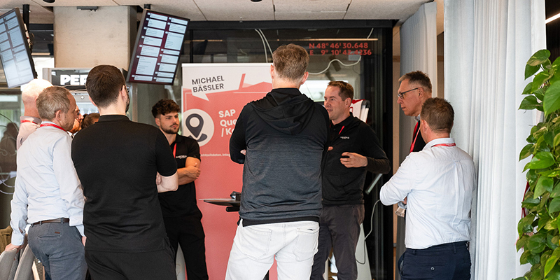 Community-Day-2025-Stuttgart-01 Teilnehmende des Community Days von Theobald Software stehen zusammen und reden.